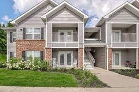 a house with a balcony and a sidewalk in front of it
