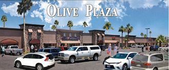 an image of olive plaza with cars parked in a parking lot
