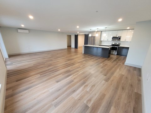 A spacious kitchen with a wooden floor and a dining area.