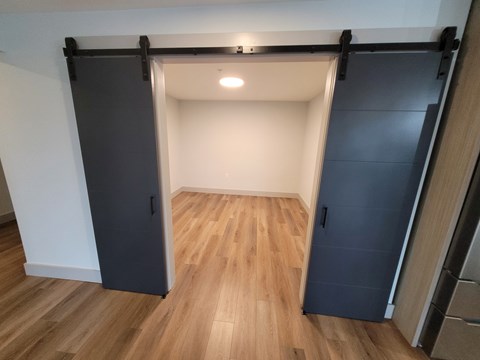 A room with a sliding door and wooden flooring.