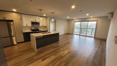 A modern kitchen with a wooden floor and a large island.