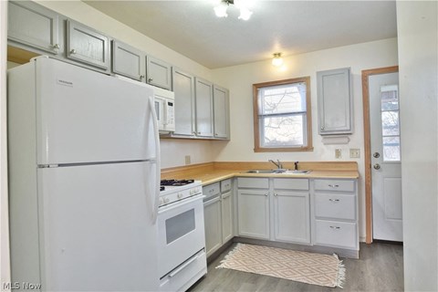 a white kitchen with white appliances and white cabinets