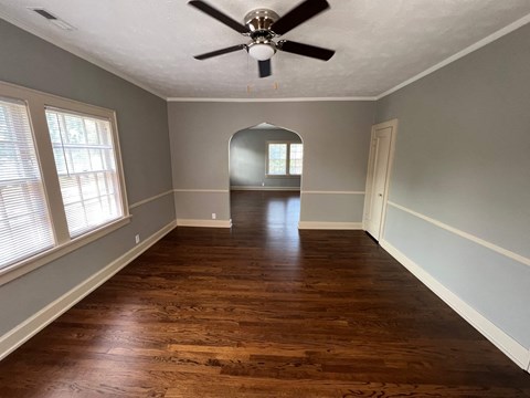 a living room with wood floors and a ceiling fan