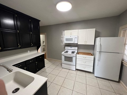 a kitchen with white appliances and black cabinets