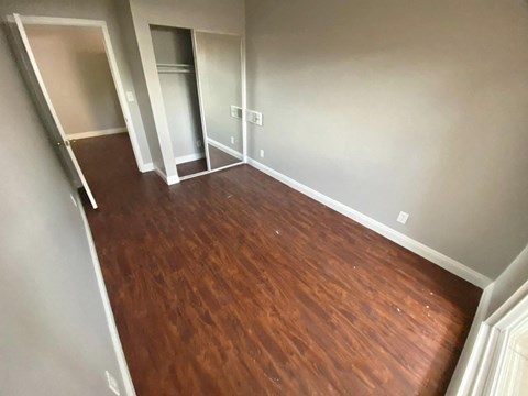 a living room with a wooden floor and a closet