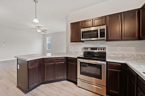 A kitchen with dark wood cabinets and stainless steel appliances.