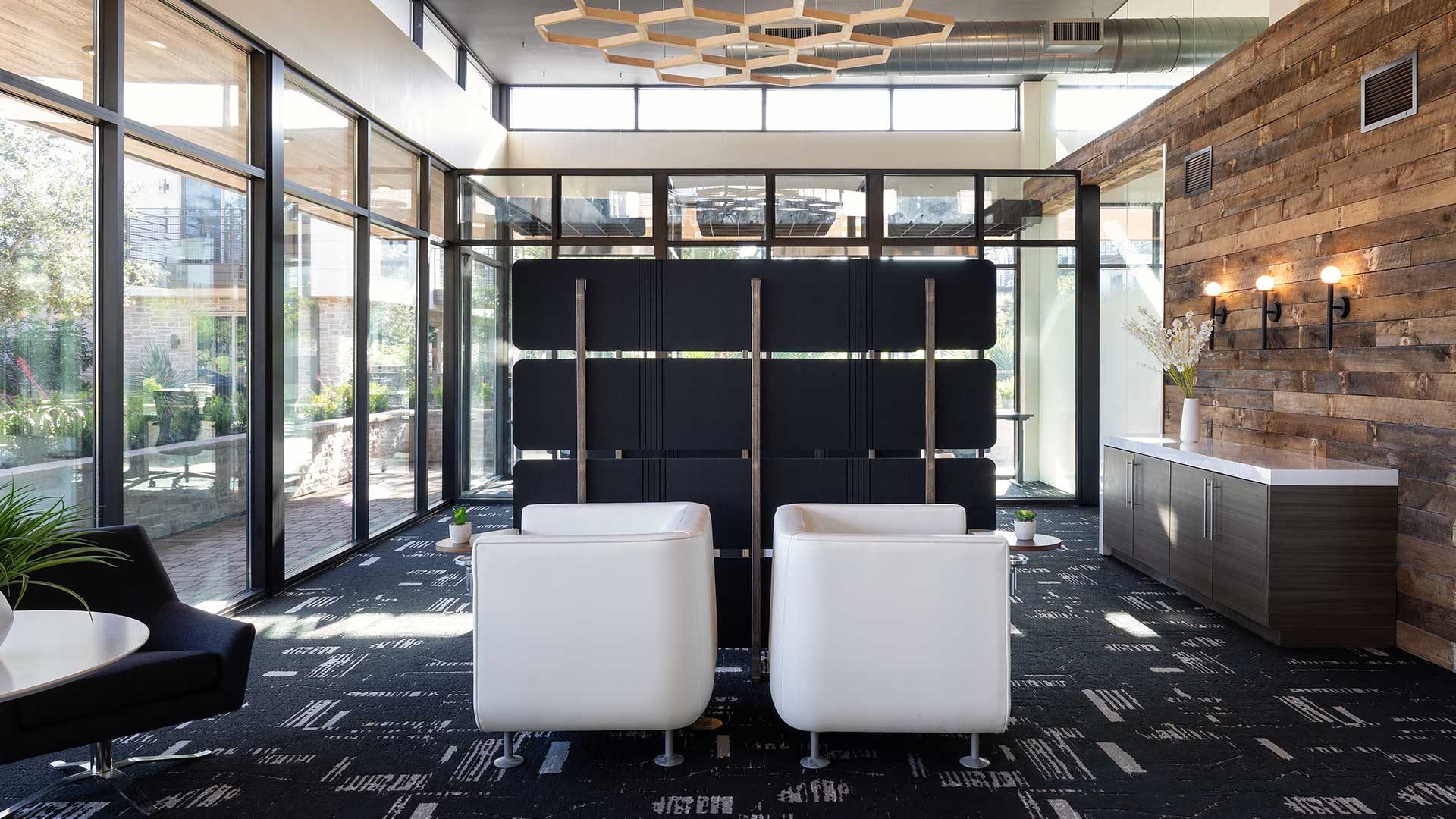 A co-working space with black chairs and a wooden wall.