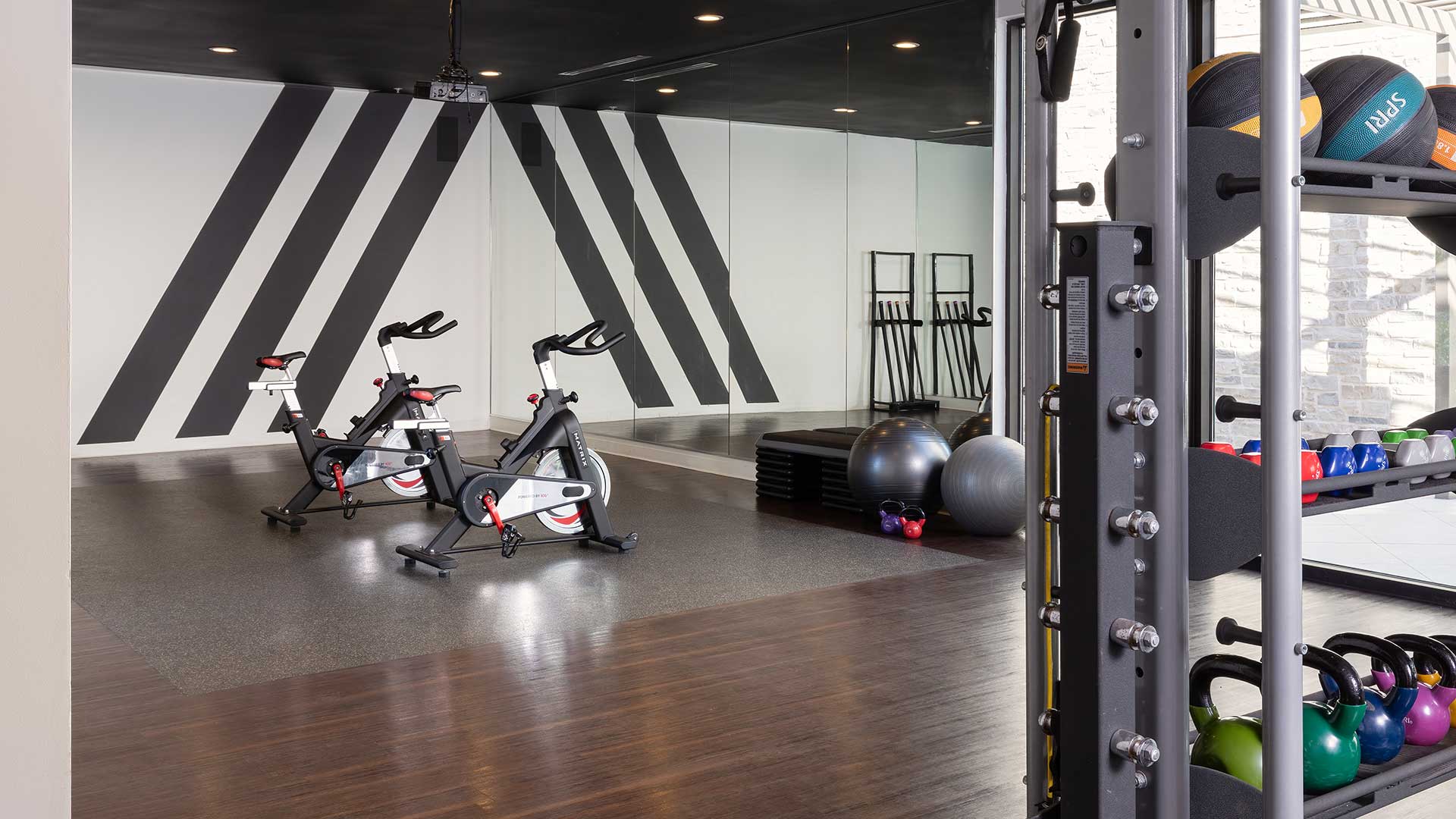 A gym room with exercise bikes and weights.