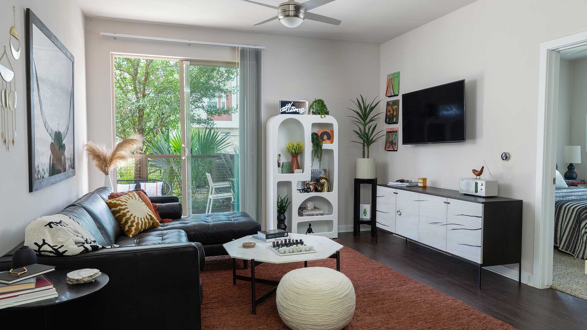 A living room with black furniture and a tv.