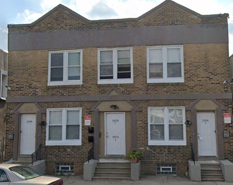 A three-story brick building with white doors and windows.