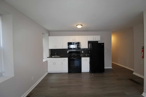 A kitchen with black appliances and white cabinets.