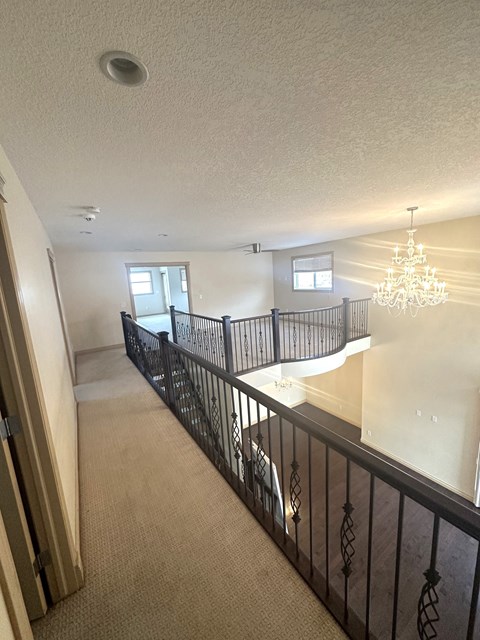 the view from the top of the stairs into the living room and dining room