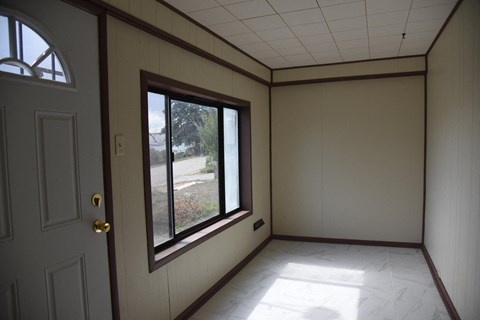 a living room with a large window and white walls