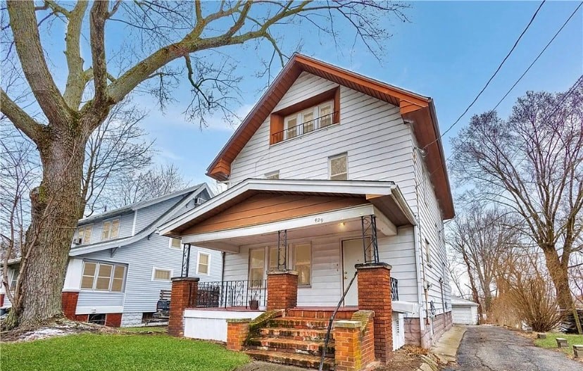 a white house with a large tree in front of it