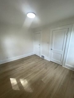 a empty living room with white walls and wooden floors