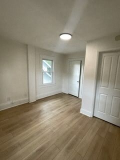 an empty living room with white walls and wooden floors