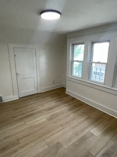 an empty living room with white walls and wood floors
