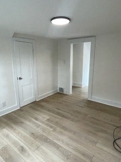 an empty living room with white walls and wooden floors