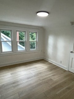 an empty living room with white walls and wood floors