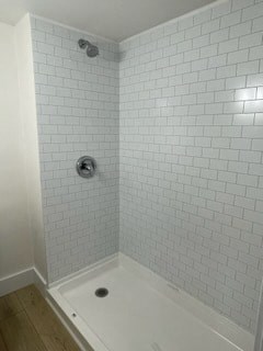 a white tiled bathroom with a shower in it