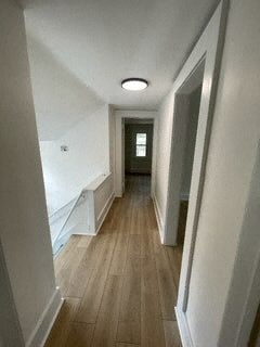 a hallway with a wood floor and white walls