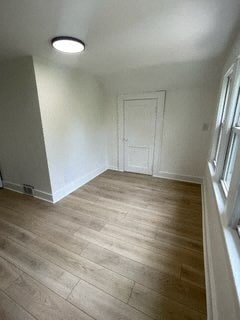 a empty room with a white door and wood floors