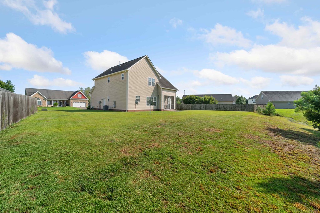 a yard in front of a house with a fence