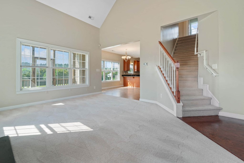 a view of the entryway of a house with a staircase and large windows