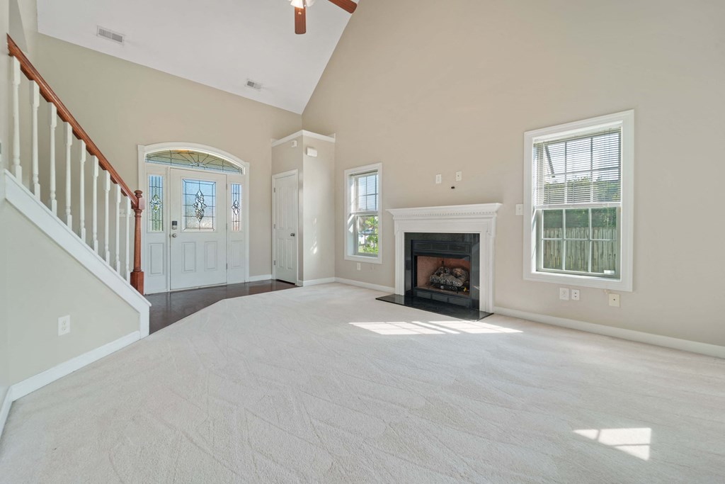 an empty living room with a fireplace and a staircase