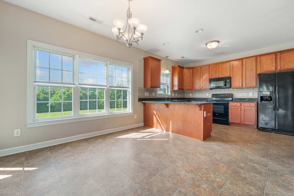a kitchen with wood cabinets and a large window