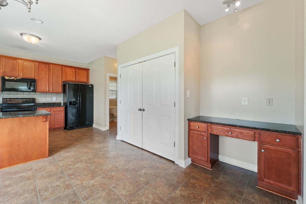 a large kitchen with wooden cabinets and a desk