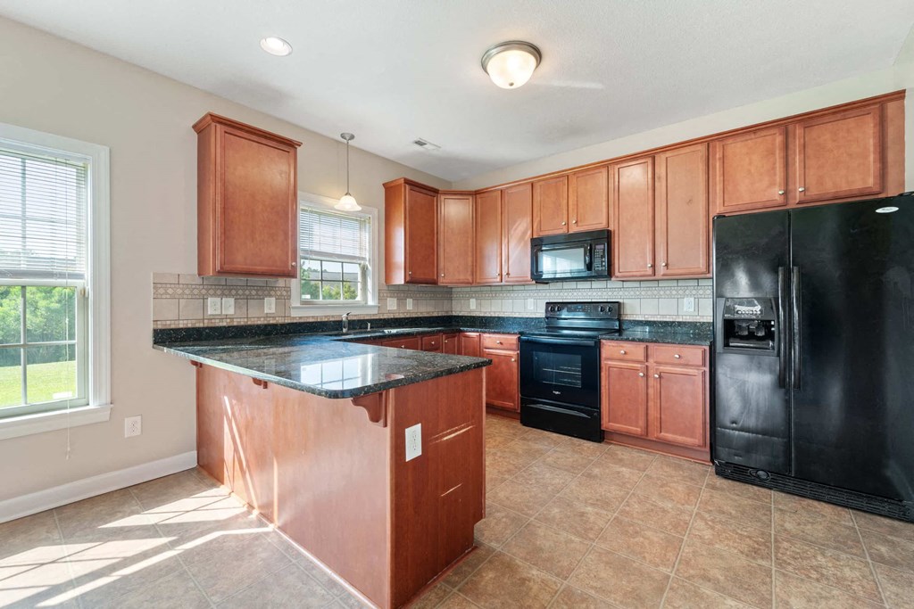 a kitchen with black appliances and wooden cabinets