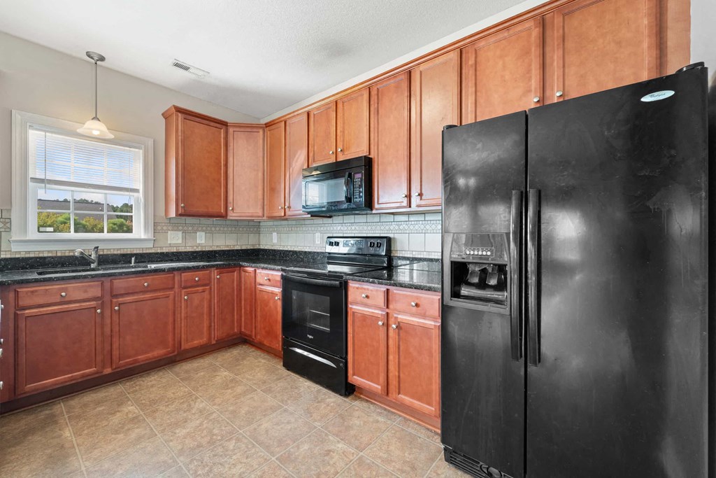 a kitchen with black appliances and wooden cabinets