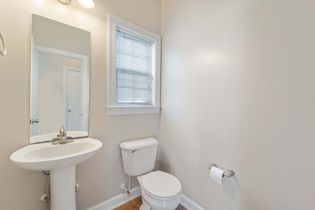 a bathroom with a sink toilet and a mirror