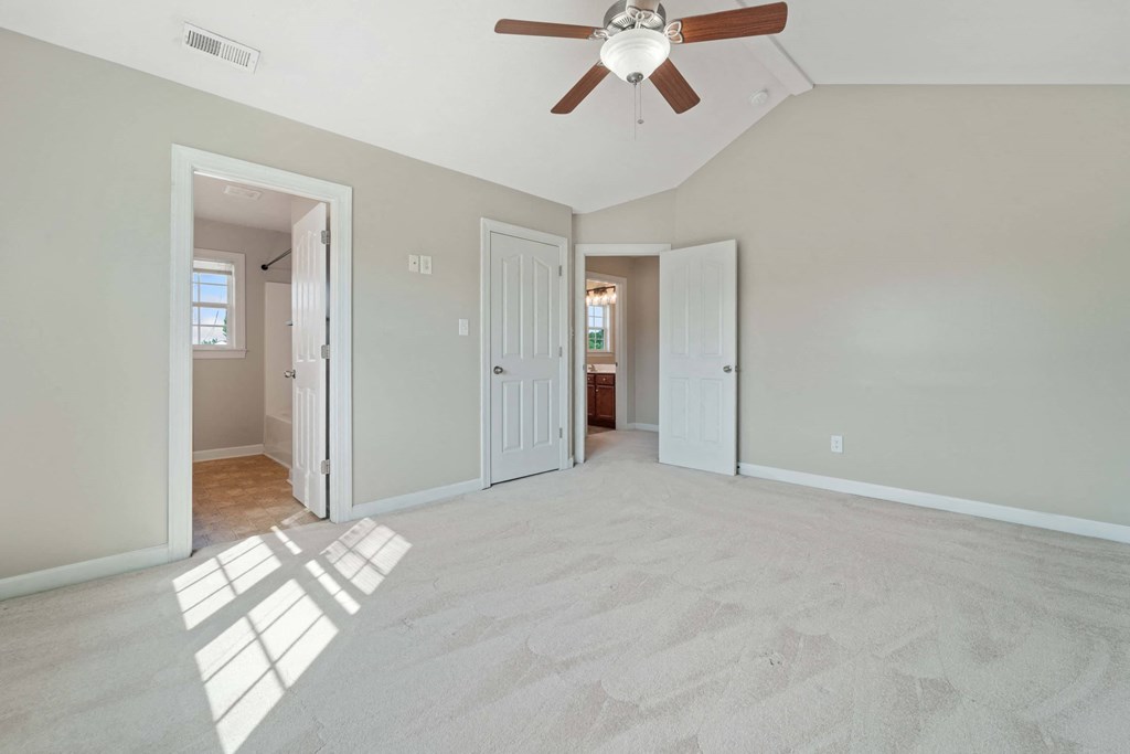 an empty living room with a ceiling fan
