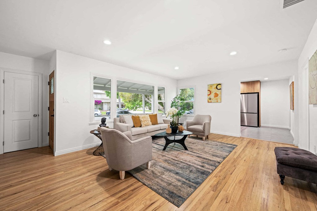 a living room with a couch and two chairs and a rug