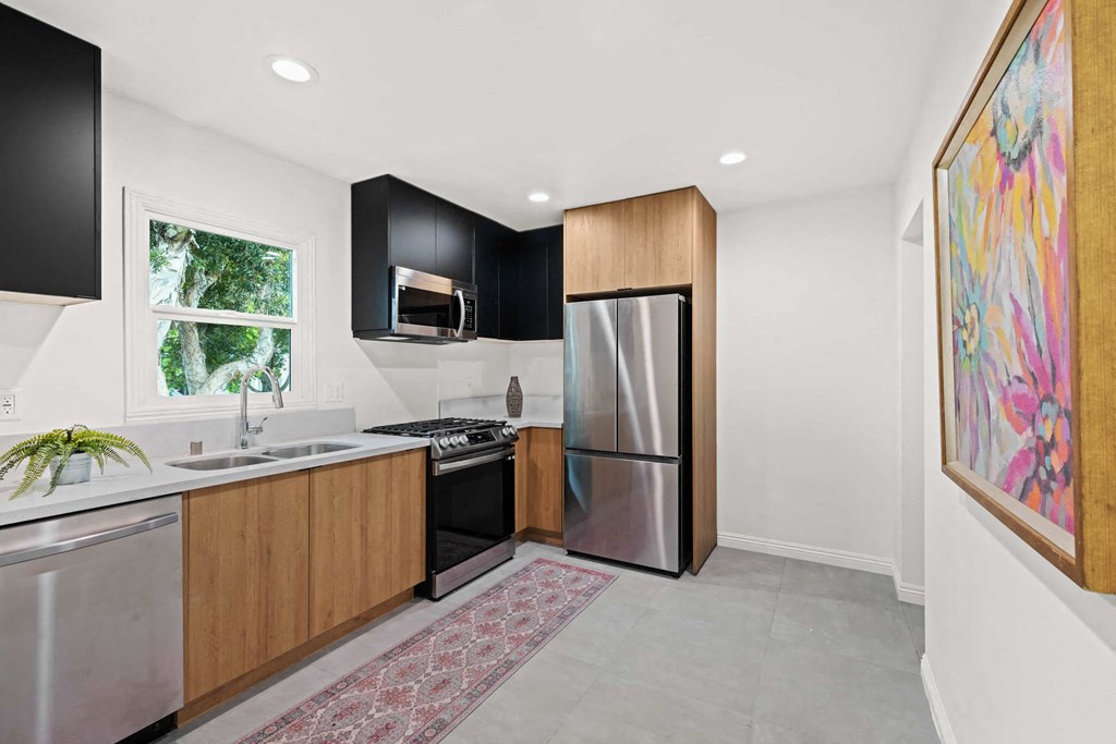 a kitchen with a stainless steel refrigerator and a sink