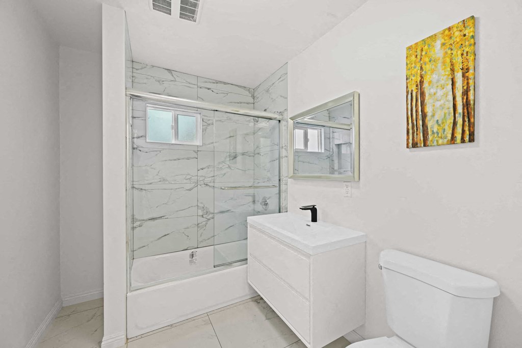 a white bathroom with a toilet and a sink