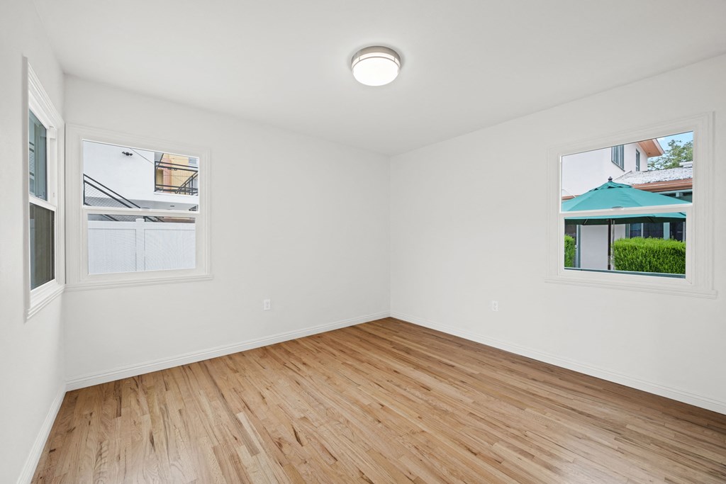 an empty living room with white walls and wood floors