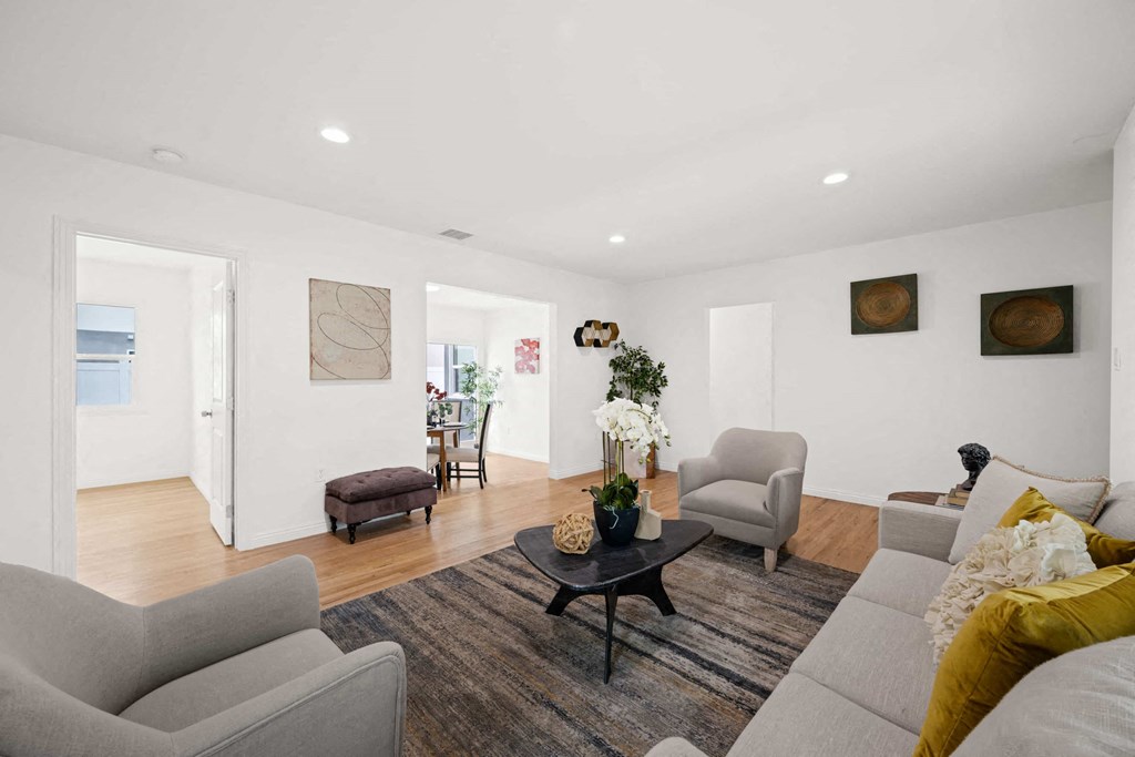 a living room with couches and chairs and a rug