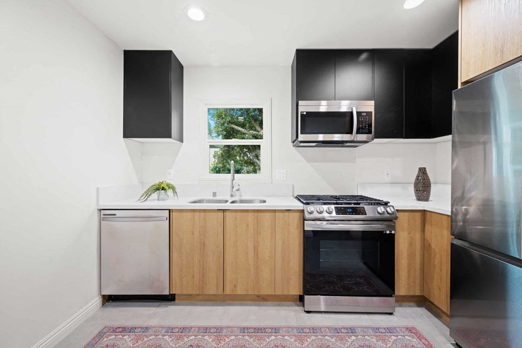 a kitchen with black cabinets and a window