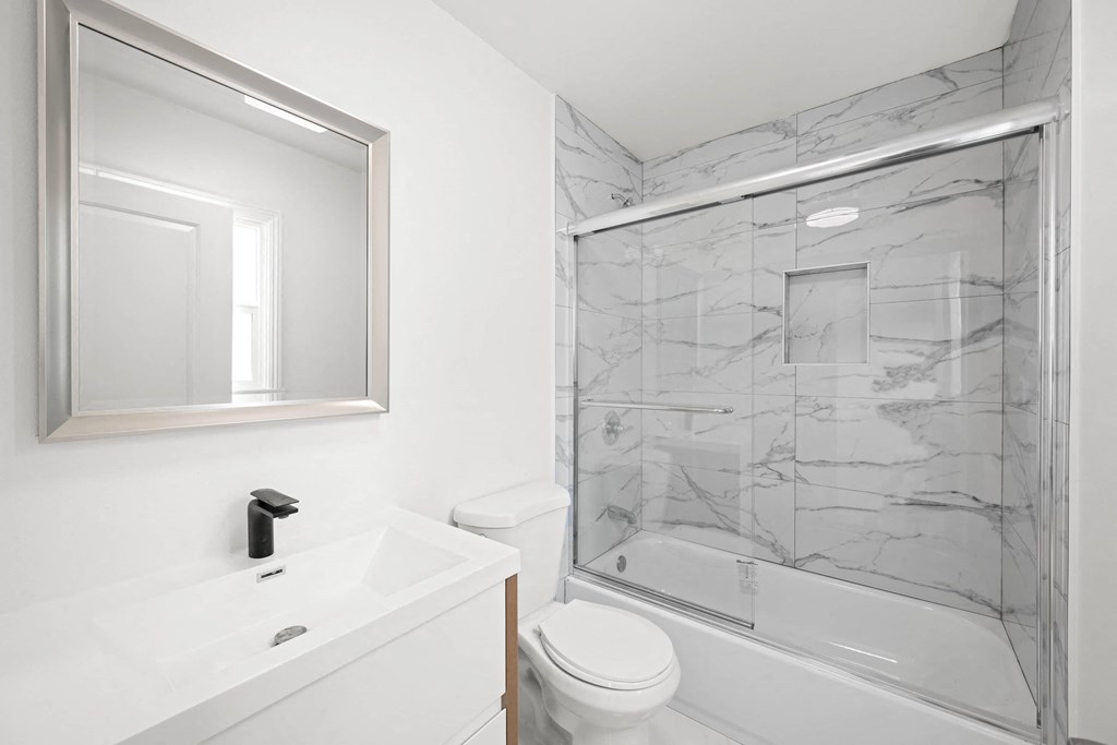 a white bathroom with a shower and a sink