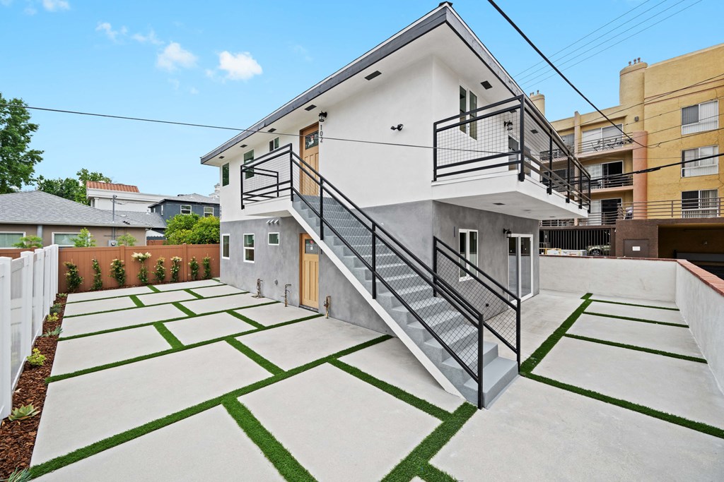the front of a house with a yard and a staircase