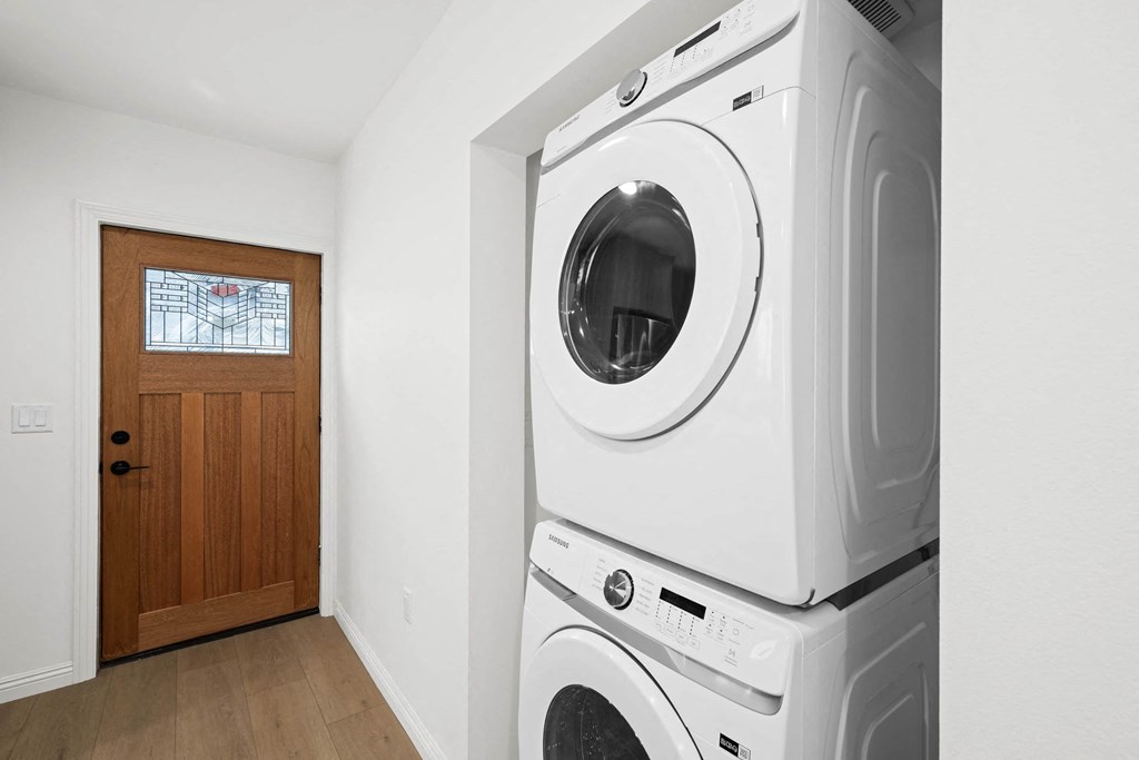 a washer and dryer in a laundry room with a wooden door