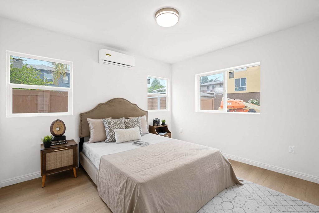 a bedroom with a bed and two windows