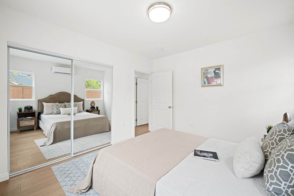 a bedroom with a large bed and a mirror