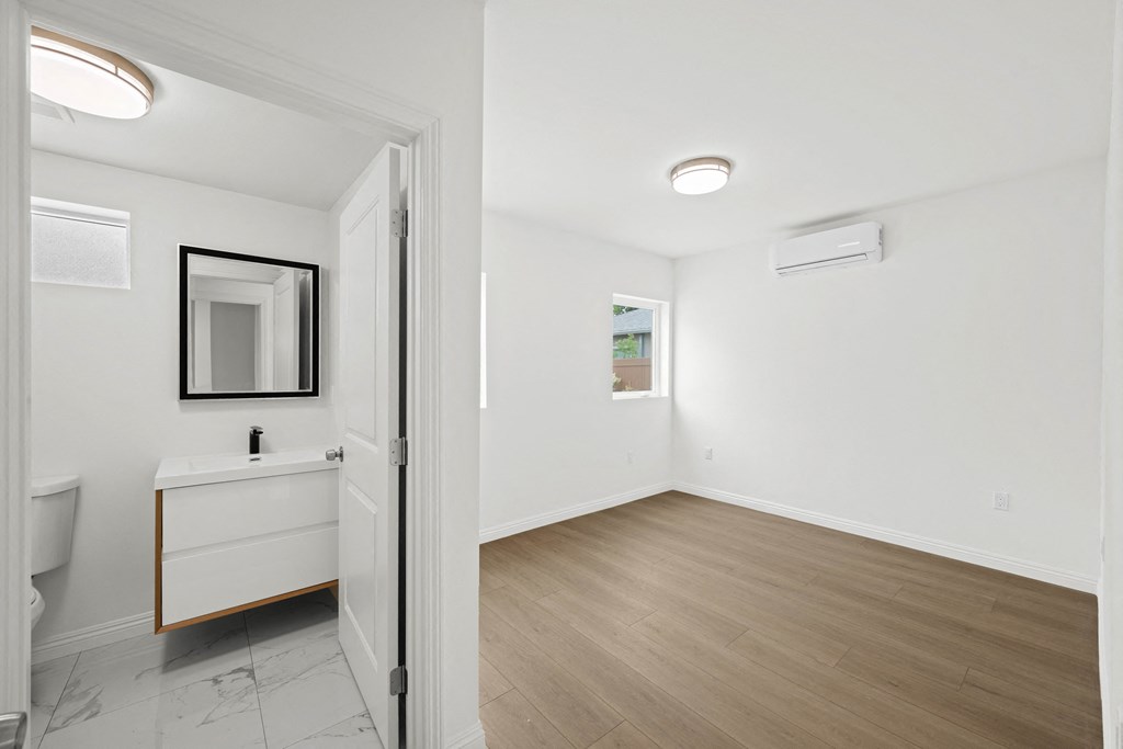 an empty room with a bathroom and a mirror