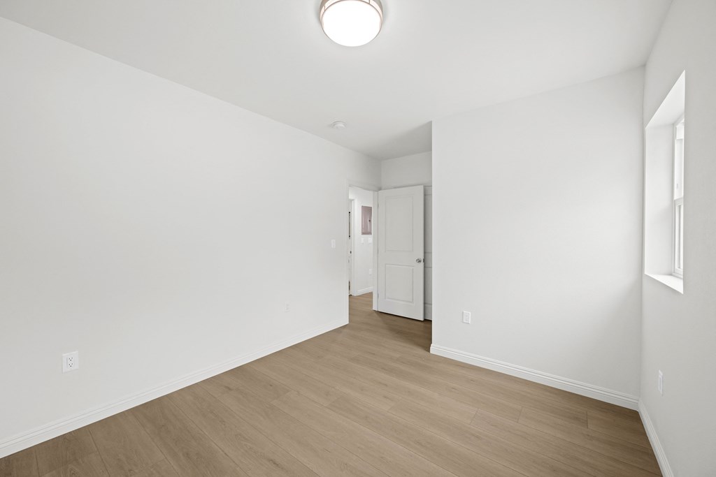 a living room with white walls and a wooden floor