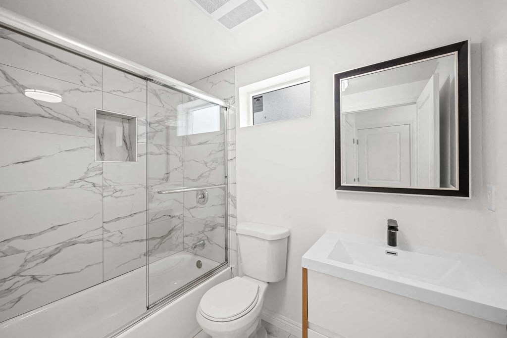 a bathroom with a shower and a sink and a toilet