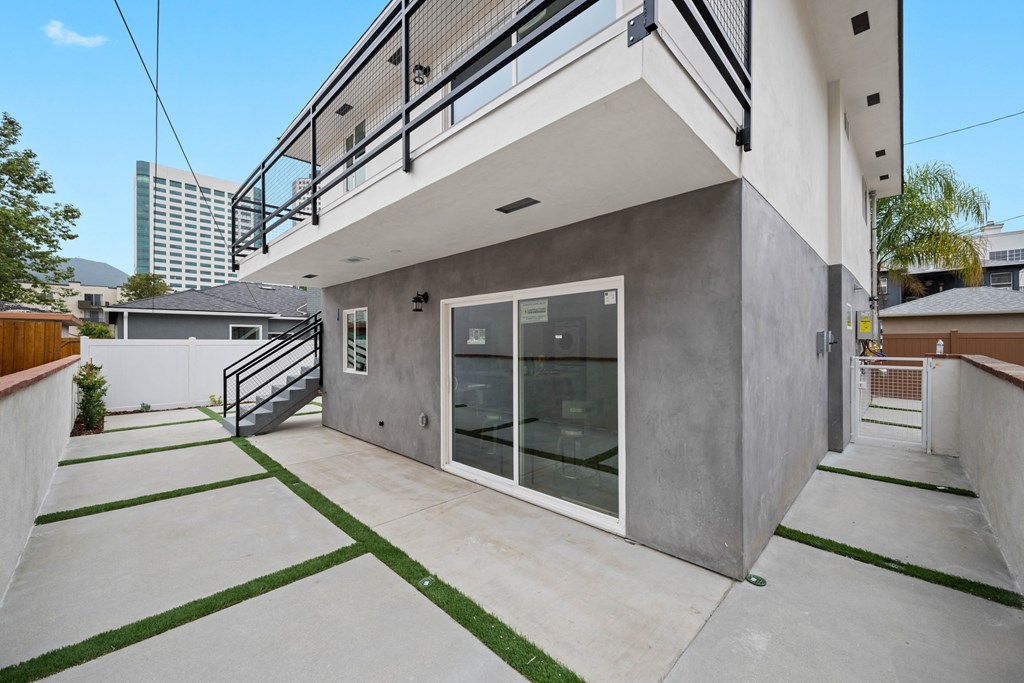 the front of a house with a patio and a glass door